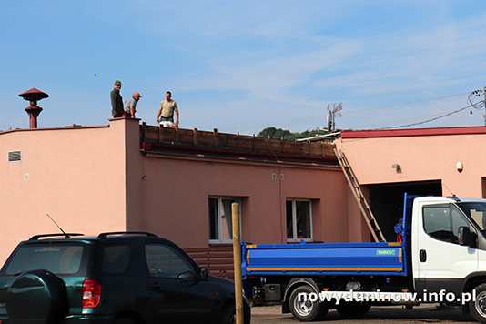Remont dachu w OSP Nowy Duninów. Zd. budynku i zaparkowanych samochodów
